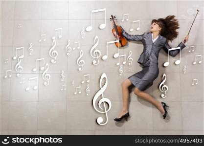 Professional in business. Attractive emotional businesswoman with violin in hands