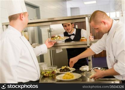 Professional kitchen cook prepare food service give meals to waiter