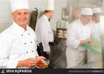 Professional kitchen smiling chef cook add spice paprika prepare food meals