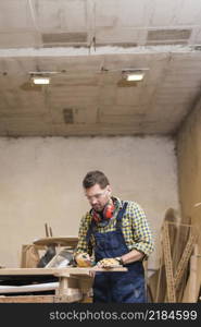 professional male carpenter taking measurement workbench workshop