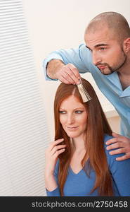 Professional male hairdresser choose hair dye color at modern salon, female customer change hair color