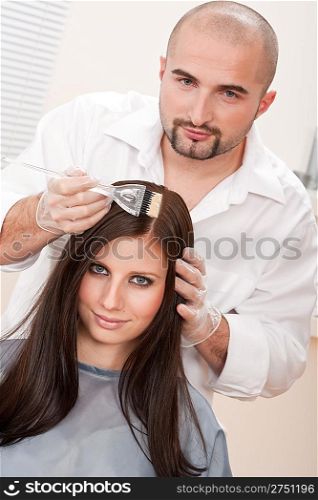 Professional male hairdresser color female customer at design salon