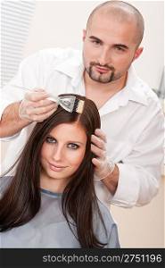 Professional male hairdresser color female customer at design salon