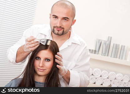 Professional male hairdresser color female customer at design salon