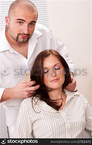 Professional male hairdresser comb female customer at salon
