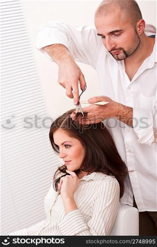 Professional male hairdresser cut with scissors at salon, customer getting new haircut