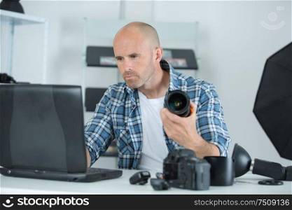 professional male photographer with digital photo camera in photo studio