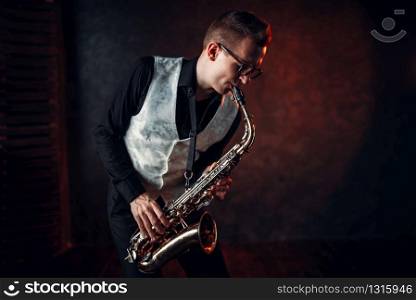 Professional male saxophonist playing jazz musical melody on saxophone