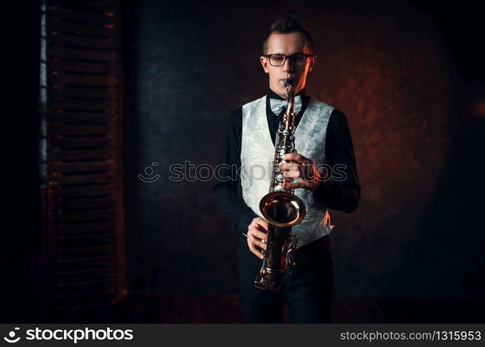 Professional male saxophonist playing jazz musical melody on saxophone. Male saxophonist playing jazz melody on saxophone