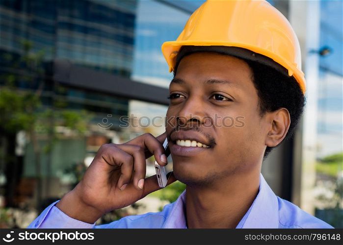 Professional man in helmet talking on the phone at street.