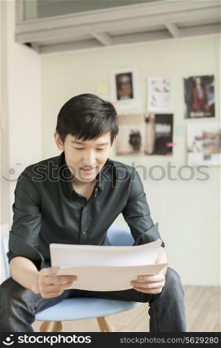 Professional Man Looking at Papers in Office
