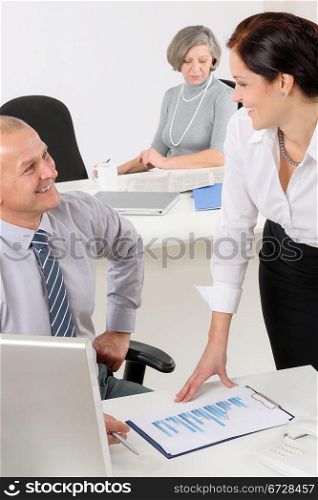 Professional mature businessman in office with attractive secretary