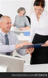 Professional mature businessman in office with attractive secretary