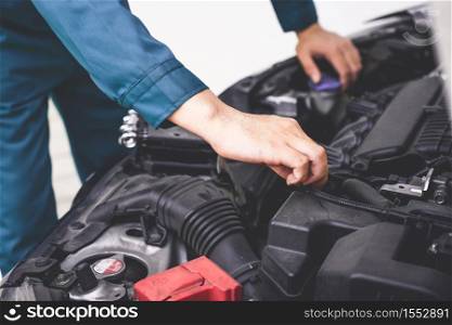 Professional mechanic hand providing car repair and maintenance service in auto garage. Car service business concept.
