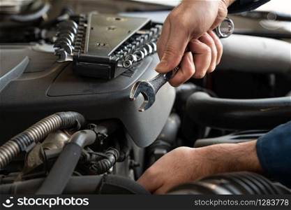 Professional mechanic providing car repair and maintenance service in auto garage. Car service business concept.. Professional mechanic providing car repair service