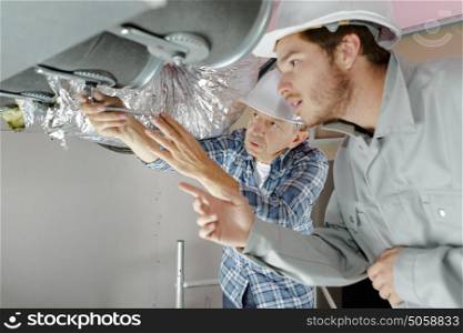 professional mechanic team repair air conditioning unit