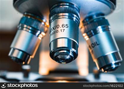 professional microscope in laboratory, science equipment and medical tools to looking micro scale, microbiology and medicine research in laboratory with microscope