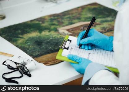 Professional oil painting condition assessment, creating a report. Conservator taking preliminary notes for their condition report on an oil painting. Professional Oil Painting Condition Assessment, Creating a Report