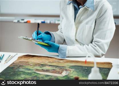 Professional oil painting condition assessment, creating a report. Conservator taking preliminary notes for their condition report on an oil painting. Professional Oil Painting Condition Assessment, Creating a Report
