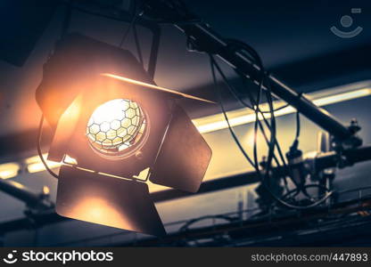 Professional orange studio spotlight hanging on the ceiling.