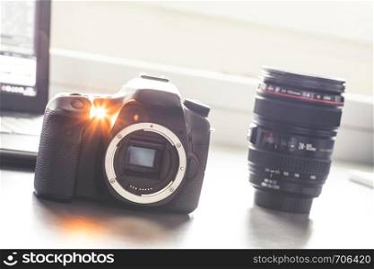 Professional reflex camera on a table, camera sensor. Lenses in the blurry background.