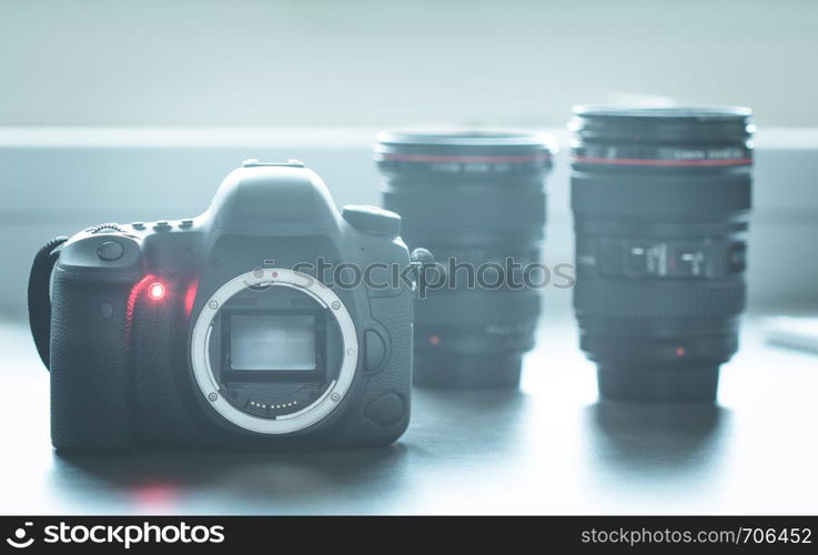 Professional reflex camera on a table, camera sensor. Lenses in the blurry background.