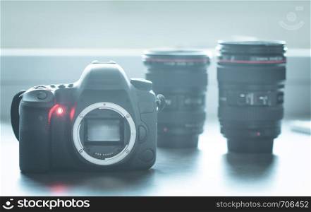 Professional reflex camera on a table, camera sensor. Lenses in the blurry background.