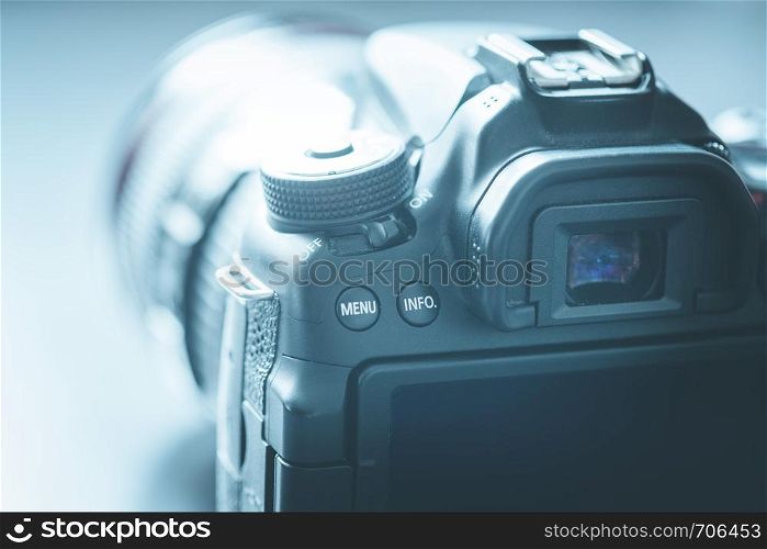 Professional reflex camera with telephoto lens on the table, cutout, blurry background