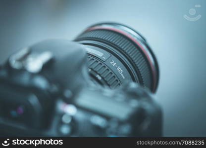 Professional reflex camera with telephoto lens on the table, cutout, blurry background