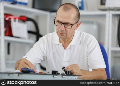 professional repairer working on device in his office