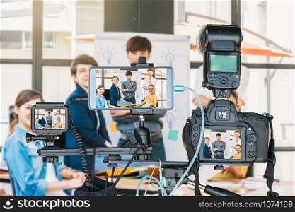 Professional set of camera with smart mobile phone and action camera on tripod over Group Of Asian and Multiethnic Business people giving the interview, Live Streaming for entrepreneur concept