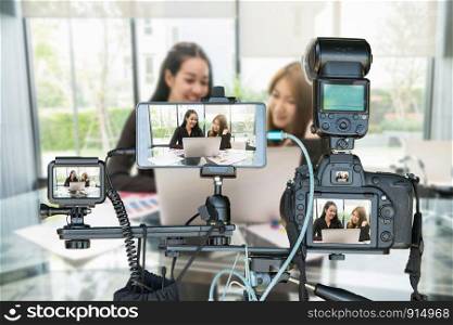 Professional set of camera with smart mobile phone and action camera on tripod over Two Asian young Businesswoman giving the interview via Live stream, Live Streaming for entrepreneur concept