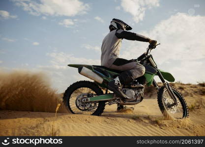Professional speed rider driving in motocross race turns with slope. Extreme sport and completion. Desert landscape. Professional speed rider driving in motocross race