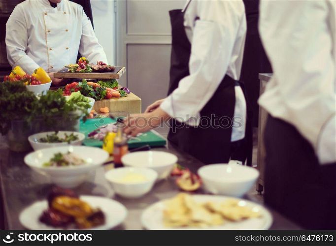 Professional team cooks and chefs preparing meal at busy hotel or restaurant kitchen. team cooks and chefs preparing meal