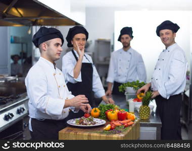 Professional team cooks and chefs preparing meals at busy hotel or restaurant kitchen. team cooks and chefs preparing meals