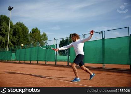 Professional tennis player with racket playing game on outside hard court. Sportsman training outdoor sport activity. Professional tennis player playing game on outside hard court