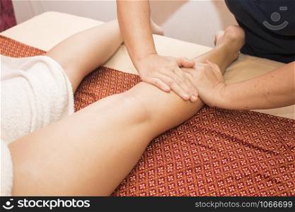 Professional therapist giving traditional thai massage to a woman in spa