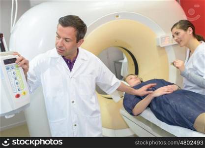professional with patient and doctor using cat scan