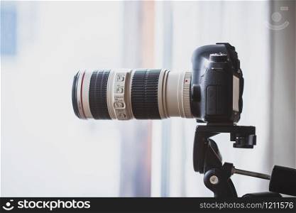 Professional with telephoto lens on tripod, surveillance and stalking