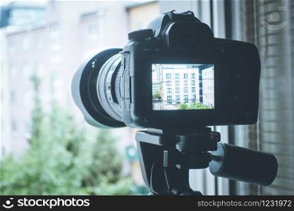Professional with telephoto lens on tripod, surveillance and stalking