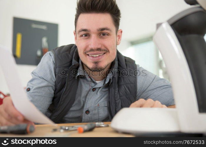 professional young repairman fixing coffee machine