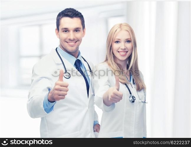 professional young team of two doctors showing thumbs up. young team of two doctors showing thumbs up