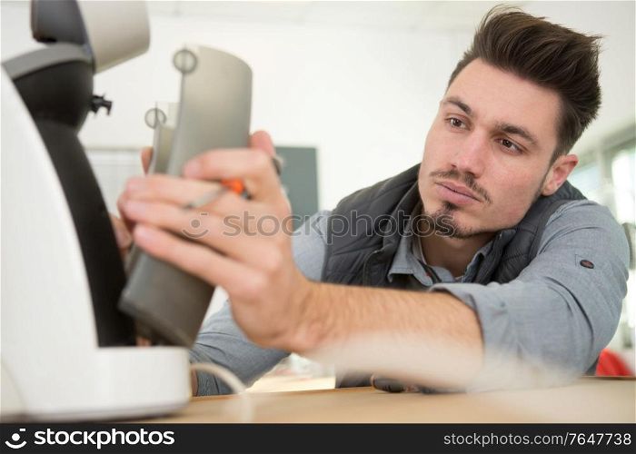 professional young worker fixing a coffee maker