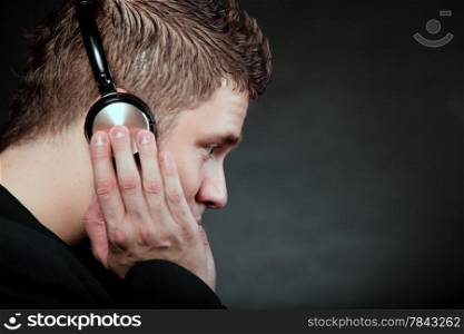 Profile of a man student with headphones listening to music black grunge background
