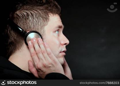 Profile of a man student with headphones listening to music black grunge background