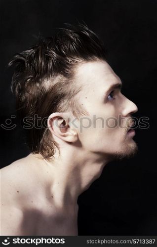 Profile of a young handsome man on black background