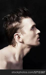 Profile of a young handsome man on black background