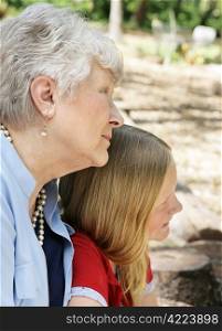 Profile of grandmother in the park with her granddaughter. There is a strong family resemblance.
