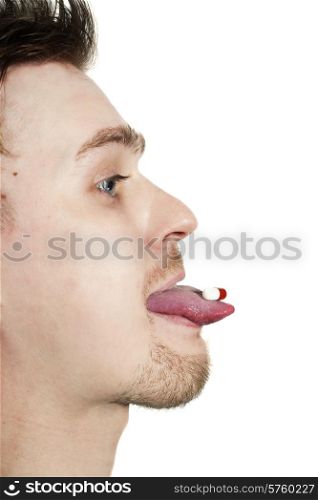 profile of young man with tablet on tongue isolated on white background