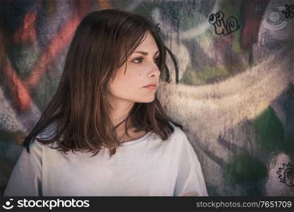 Profile portrait of a teenage girl with long hair on a wall background. Portrait of a teenage girl with long hair